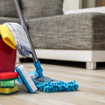 Mop and cleaning bucket on a hardwood floor during a residential cleaning visit